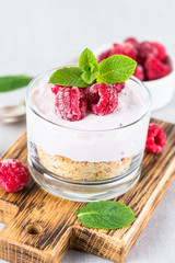 No baked cheesecake with raspberry in glass jar.