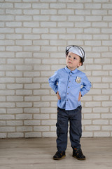 a 4 year old boy plays a policeman and look and points left to a place for copy space