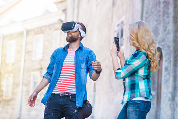 Obraz na płótnie Canvas Couple walking in the street in augmented reality headset. Virtual reality and futuristic technology concept.