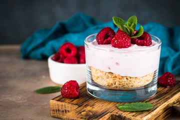 No baked cheesecake with raspberry in glass jar.