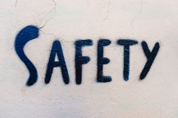 Safety word written with black paint on a wall.