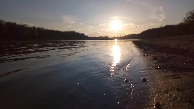Waves off the river at sunset The quiet evening wind rolls small waves on the bank of the Desna River