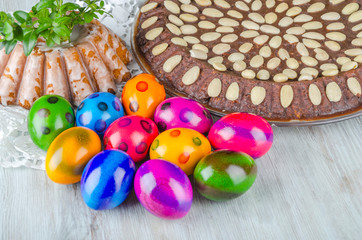 Fototapeta na wymiar colorful easter eggs and easter cake on wooden table