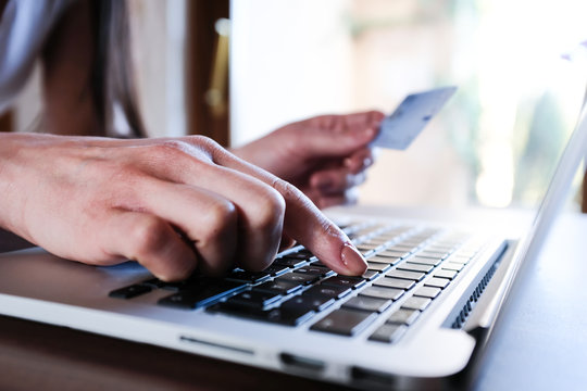 Frau bezahlt Online mit ihrer Kreditkarte am Laptop