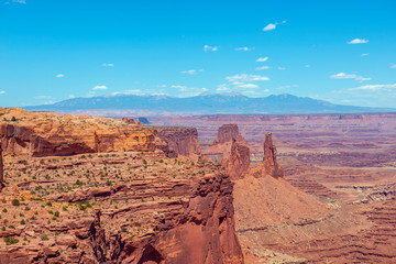Canyon and Washer Woman Arch near Mesa Arch in Canyonlands National Park with La Sal Mountains at the background, Moab, Utah, USA.