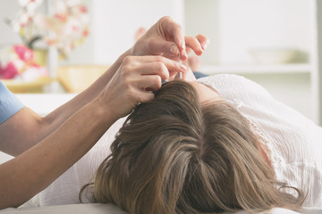 Obraz na płótnie Canvas Acupuncture therapist applying acupuncture needle
