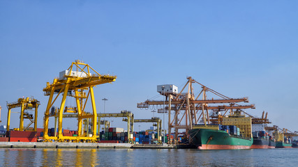 Obraz premium Container ship in export and import business and logistics. Shipping cargo to harbor by crane. Water transport International