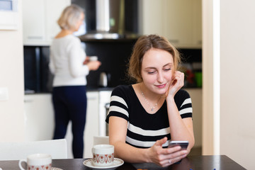 Woman with phone at kitchen