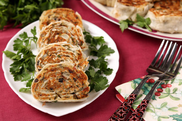 Fried lavash rolls with potatoes and mushrooms are located on a plate