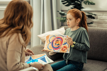Cute pleasant girl holding a colorful painting
