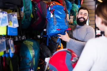 Couple choosing rucksack in store