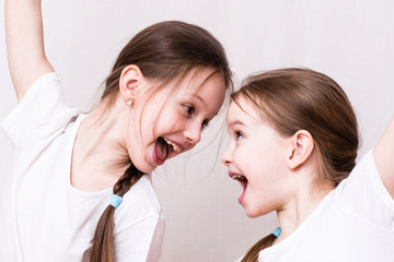 Two girls sisters emotionally smile at each other