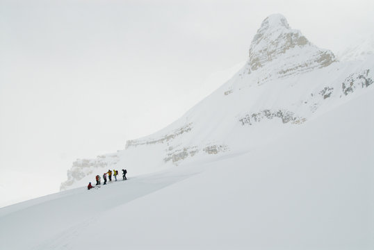 A group of skiers take a quick break on a distant ridge on thier final push to the summit of Mount Kimmel, Canadian Rockies.
