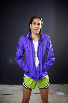 Female runner poses for a photo with hands inside jacket pocket in San Diego, CA.