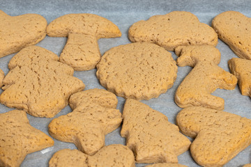 fresh baking cookies of different shapes on a baking sheet close-up
