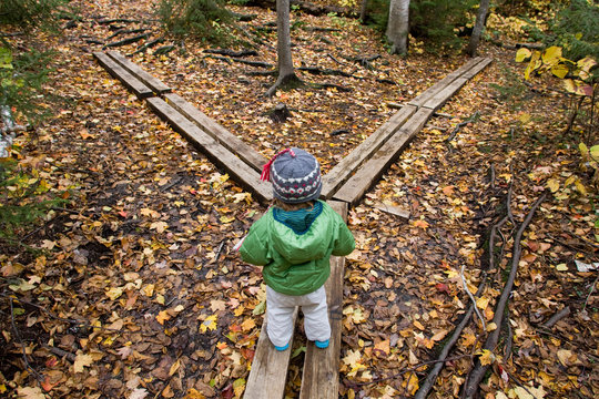 A young girl walks across hiking bridges in Grafton Notch State Park, Maine.