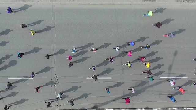 aerial top down shot of crowd of runners running during marathon on city road