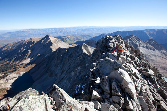 A young man crossing an exposed ridge line at the summit of Capitol mountain. Capitol is one the hardest 14ers in Colorado to climb.