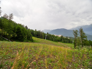 The green slope of the mountain with the cable cars