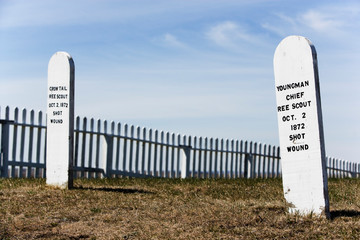 Old wooden annotated grave markers against sky