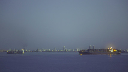 Fototapeta na wymiar Waterfront of cargo ships and panorama of Miami in night