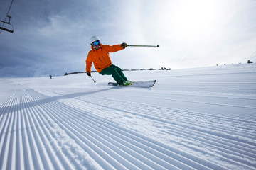 A male alpine skier smiles while skiing untracked groomers in Vail, Colorado.