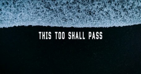 Aerial bird's eye view wave gradually washes off white lettering This Too Shall Pass against the dark bottom. Motivational words. Loopable. 4K