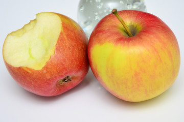 Angebissener Apfel mit weiterem Apfel in rot-hellgrüner Färbung