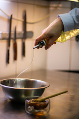 The chef cooking chicken wings in a sauce in the kitchen. Decorating the dishes with colored blobs. Lymon. Chicken. Sauce with honey and seasonings