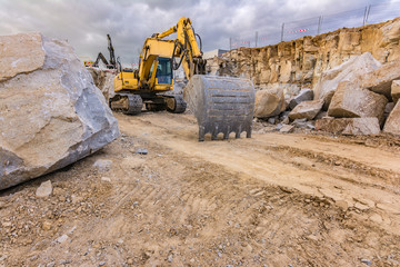 Obraz premium Excavator in a work extracting granite to transform into gravel