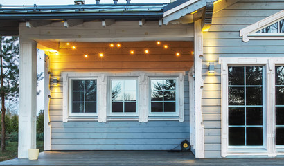 Facade of a beautiful wooden house. Fashionable lighting on the facade. Latvia