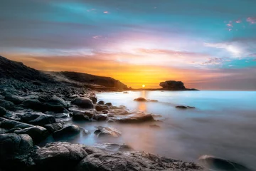 Photo sur Plexiglas Salle de bain Lever du soleil sur une côte de pierre à Fuerteventura, îles Canaries. L& 39 ambiance lumineuse et l& 39 environnement rappellent un paysage lunaire. La longue exposition rend la mer douce. bonne humeur maussade