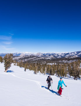 Heather Peebles and Christian Hiller skiing  toward the Ostrander Hut with Half Dome in the background.  The Ostrander Hut is the the premiere back country ski hut in the Sierra Nevada range, located 10 miles into the Yosemite Backcountry accessable only by skis or snowshoes, Yosemite National Park, California
