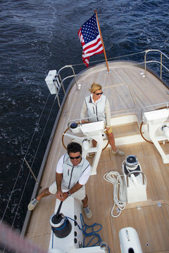 A woman is at the helm of luxury sailing yacht "Isobel" as she cruises off the coast of Maine. "Isobel" is a 75' cold-molded Spirit of Tradition yacht, designed by Stephens & Waring Yacht Design and built by Brooklin Boatyard, Maine.