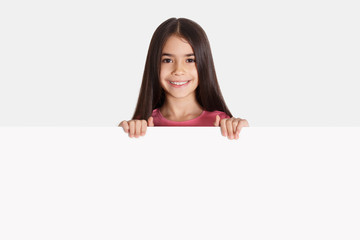 Schoolgirl with white empty banner for your advertisement
