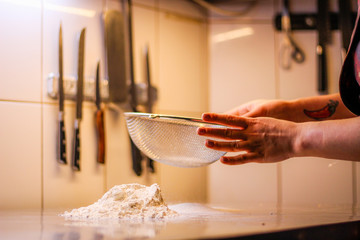 The chef mixes the dough from flour and eggs. Smoke flour Sifting flour. Chef's hands. Kitchen processes