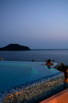 A woman in the main pool overlooking the Pacific Ocean at La Casa que Canta luxury resort in Zihuatanejo, Mexico. (releasecode: CM_MR1028, CM_MR1031)