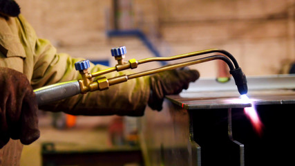 Construction plant. A worker heating up the iron detail