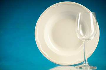 A plate and a glass on a blue background