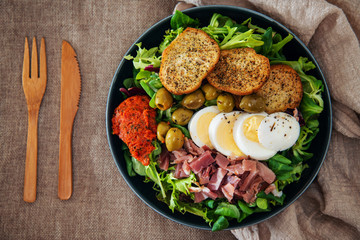 Salad with speck ham and egg, tomatoes