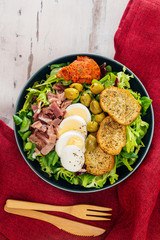 Salad with speck ham and egg, tomatoes