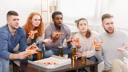 Friends watching TV, eating pizza and drinking beer