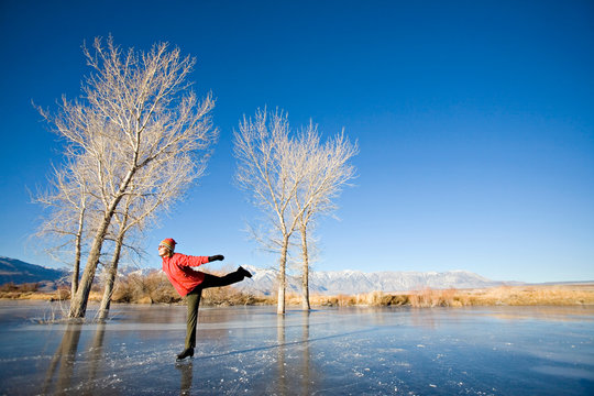 Woman Ice Skating On Frozen Pond