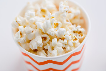 fast food, junk-food and unhealthy eating concept - close up of popcorn in disposable paper cups with zig zag pattern