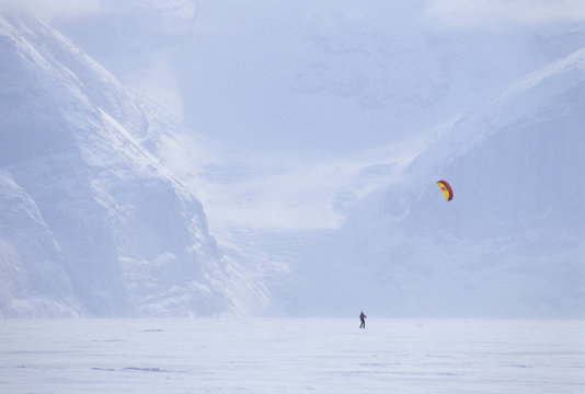 A woman kite skiing on Gibb's Fjord, Baffin Island, Nunavit territory, Canada.