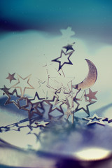 Silver half-moon and stars on dark blue background