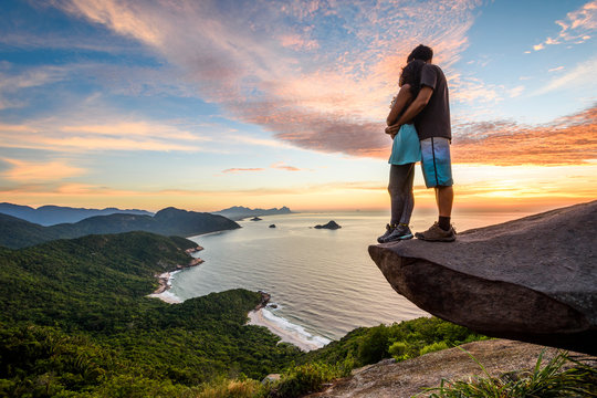 Couple standing on edge of rock