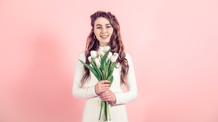 Young girl with tulips on a colored background