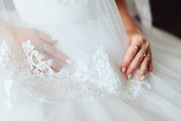 hands of the bride in a white dress with a beautiful manicure 1