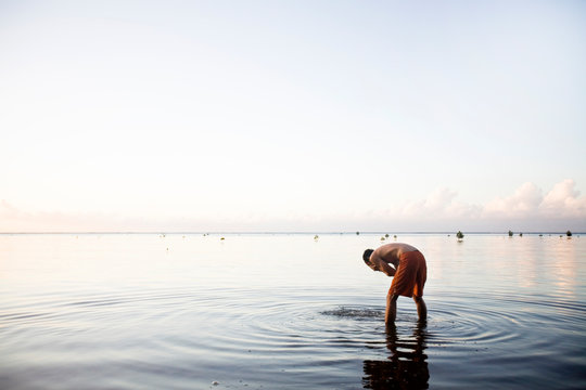 Man washing his face in the ocean
